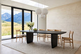 Frontino dining table in Black in a Waterton house, with a travertine wall