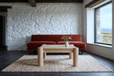 Furore coffee table in Biscotti Oak seen low from the front in a Dingle farmhouse, with whitewashed rubble stone