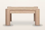Furore coffee table in Biscotti Oak from the front on a warm white studio backdrop: two column legs and the set-back apron