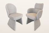 The two Gaiole chairs side by side: the armless side chair with its tall rounded back and the armchair with wrap arms and a h