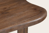 Close-up of the Gaiole table's rounded edge: solid mango in a dark walnut finish, a leg below