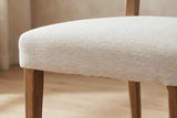 Close-up of the Galen seat, the sandy beige herringbone wrapped over a softly rounded edge above a solid ash leg