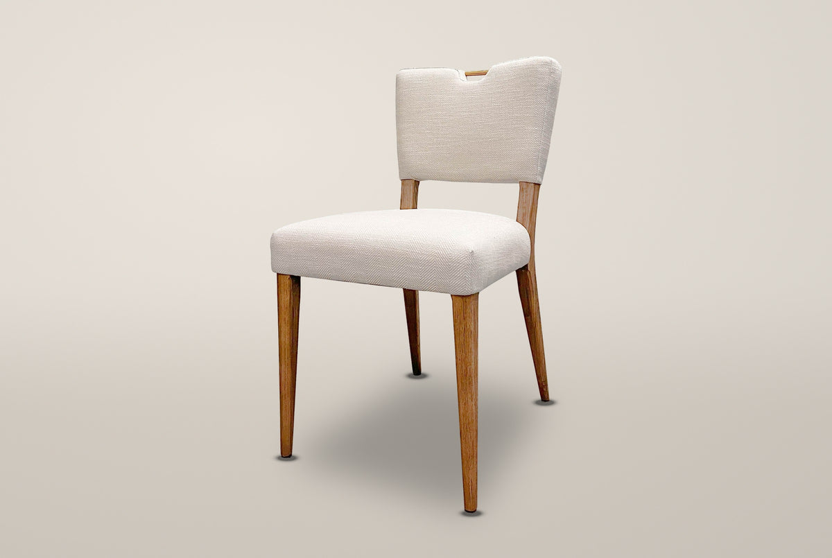Galen herringbone dining chair in Sandy Beige, three-quarter view on a warm off-white studio backdrop