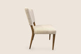 Galen dining chair in Sandy Beige from the side, with the back leaning gently and the rear legs angled back