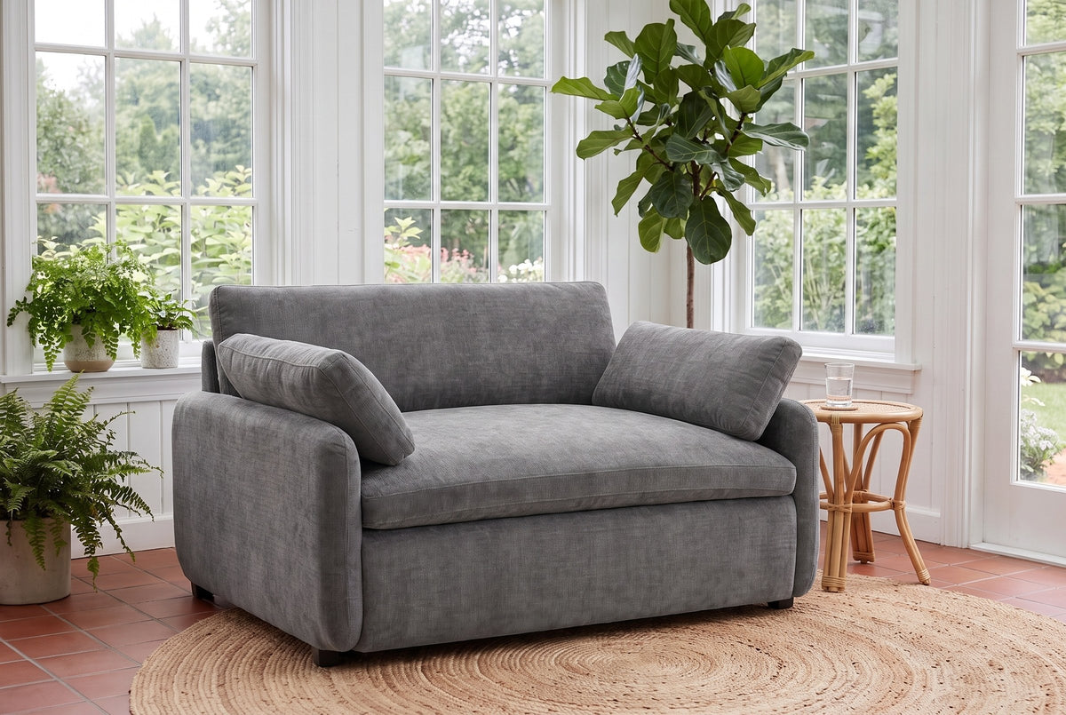 Gallipoli chair in charcoal gray on a jute rug in a Victoria garden room with ferns and tall paned windows