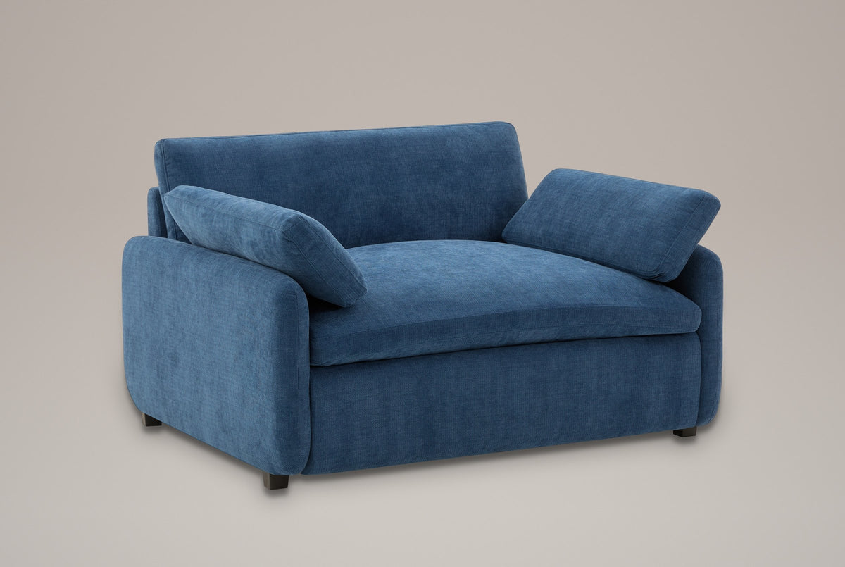 Gallipoli oversized chenille accent chair in denim blue, three-quarter view on a warm grey studio backdrop