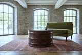 Gangi coffee table in Walnut seen low before an olive velvet loveseat in a Fergus stone mill loft