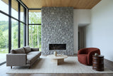 Gangi side table in Walnut beside a rust boucle lounge chair in a Bromont mountain house