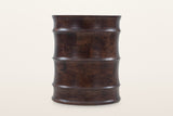 Gangi side table in Walnut at eye level on a warm white studio backdrop: the wavy profile of four curved bands and three roun