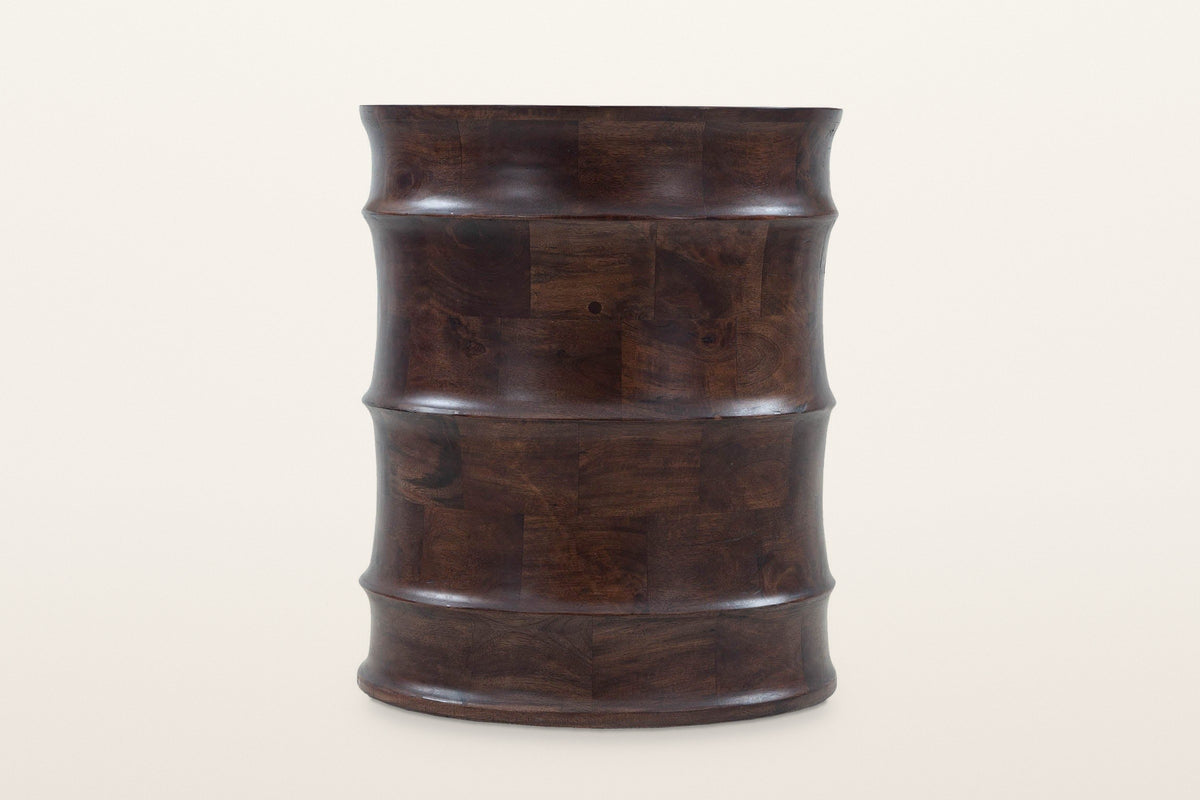 Gangi side table in Walnut at eye level on a warm white studio backdrop: the wavy profile of four curved bands and three roun