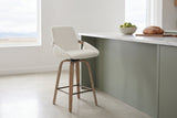 Gardone counter stool in ivory beside a sage-green kitchen island with a white marble top in a bright Calgary kitchen