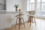 Two Gardone counter stools in ivory at a white island with a terrazzo top in a Montreal loft kitchen