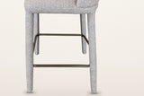 Gavi base from the side: four fabric-wrapped legs and the aged-gold metal footrest