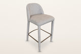 Gavi upholstered counter stool in beige, three-quarter view on a warm white studio backdrop