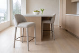 Two Gavi counter stools in beige at a white-oak kitchen island with a white quartz top in a Vancouver kitchen