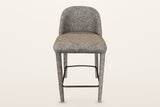 Gavi counter stool in brown, straight front view: the low rounded back, the thick seat