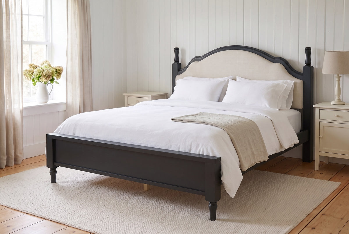 Gradara bed in black made up with white linen in a white board-walled farmhouse bedroom with pine floors