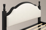 Close-up of the black Gradara headboard: two turned finials, the moulded crest and the beige linen-look panel