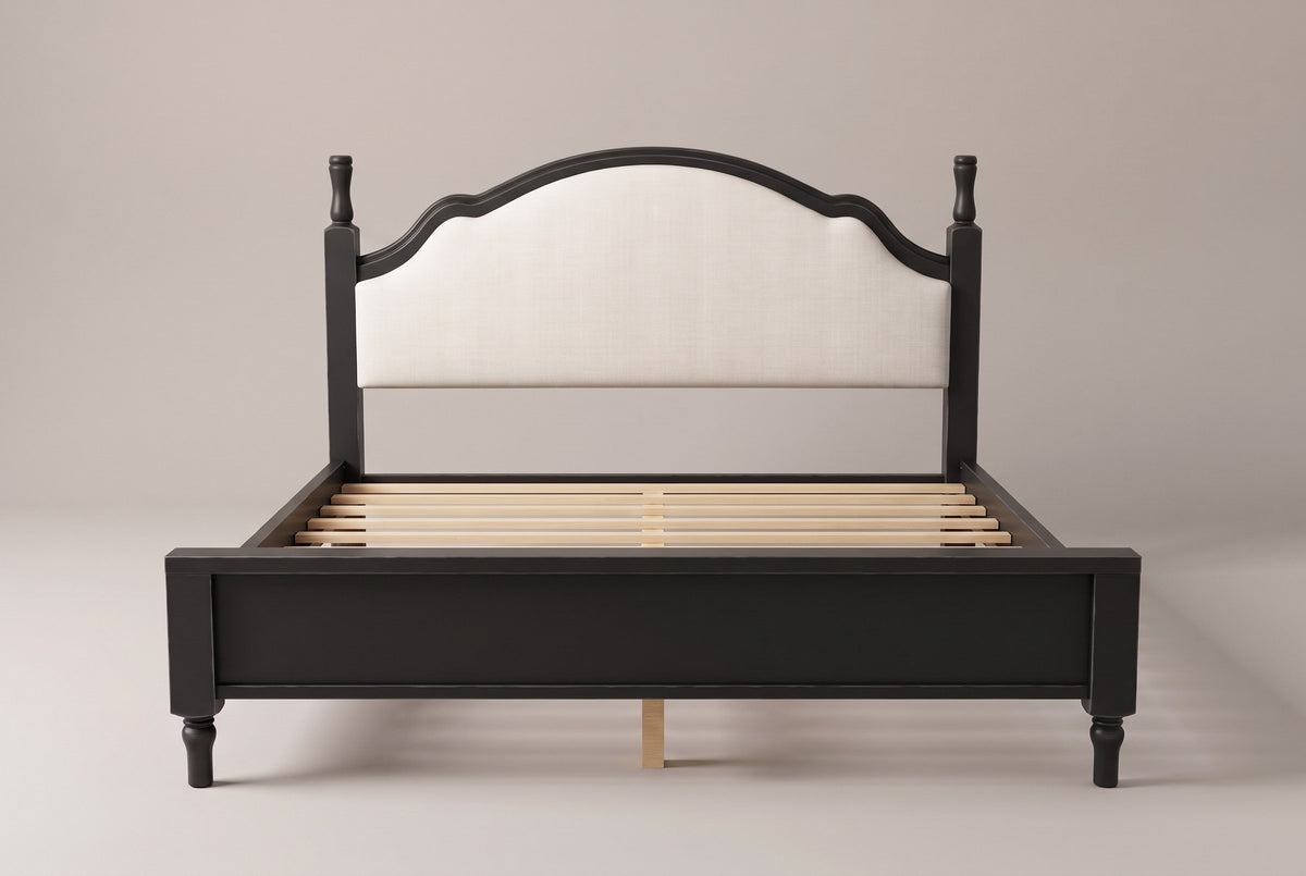 Gradara bed in black, straight front view: arched upholstered headboard between two turned finial posts