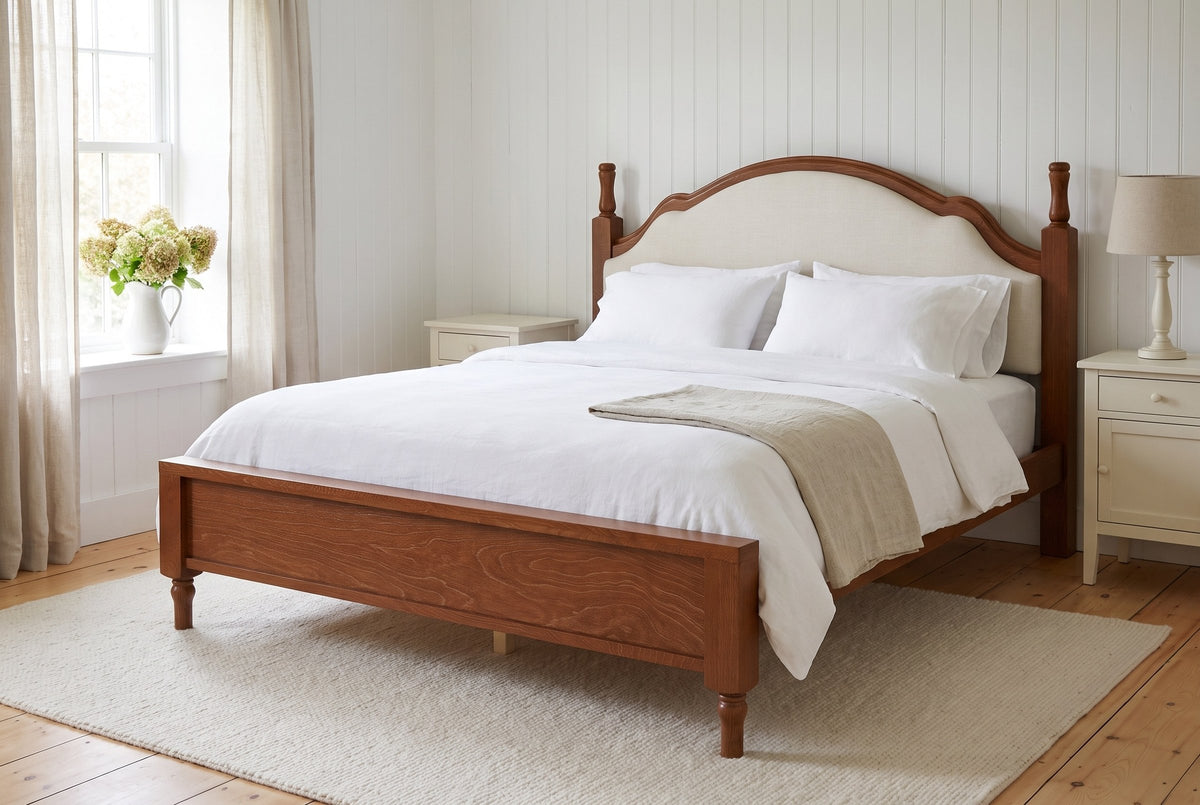 Gradara bed made up with white linen in a white board-walled farmhouse bedroom with pine floors