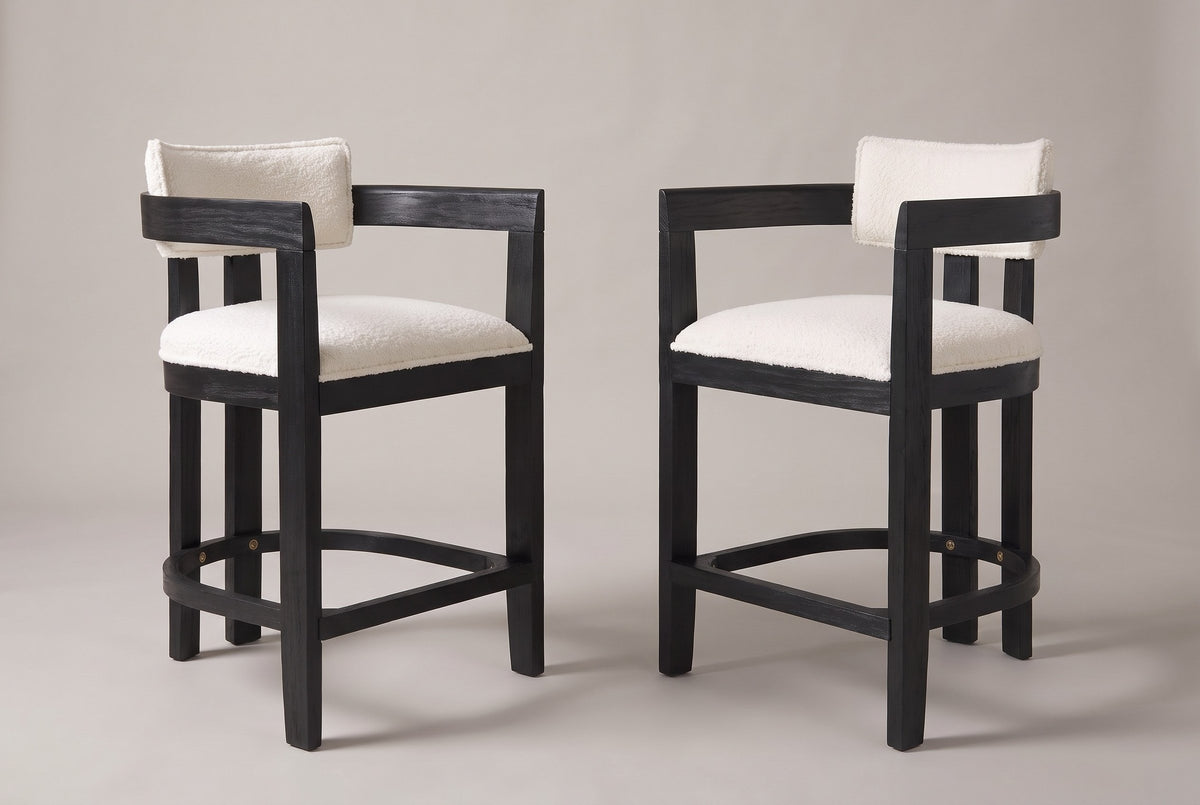 Gradisca counter stools, set of 2, in Black with ivory boucle, angled toward each other on a warm grey studio backdrop