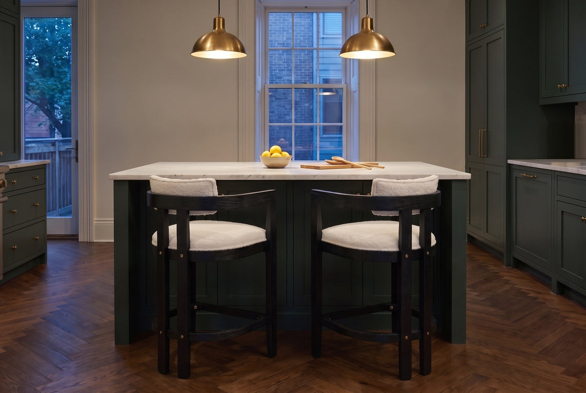 Two Gradisca counter stools in Black at a marble island under brass pendants in a Toronto townhouse kitchen at dusk