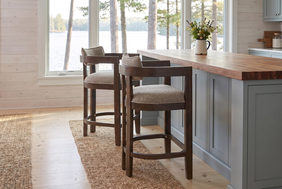 Two Gradisca counter stools in Espresso Taupe at a butcher-block island in a Muskoka cottage kitchen with a window onto the l