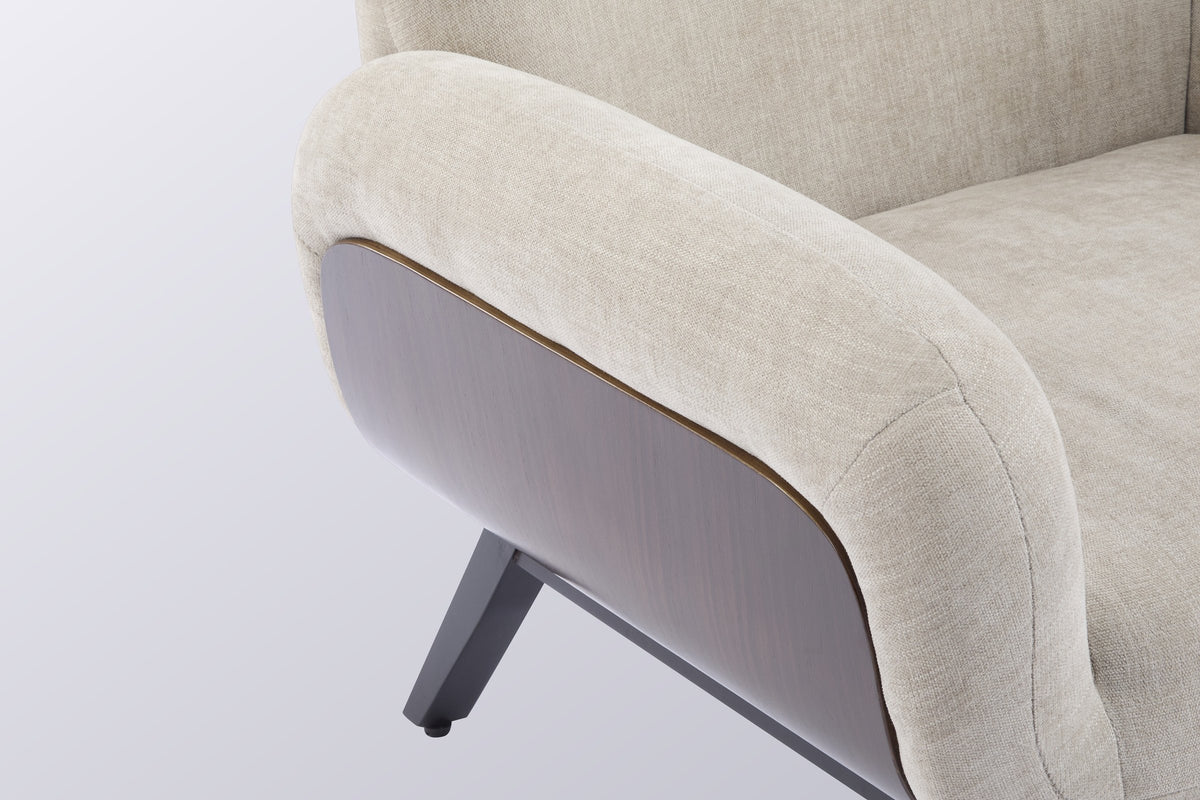 Close-up of the plump oat arm over the curved walnut-tone wood panel and its layered edge