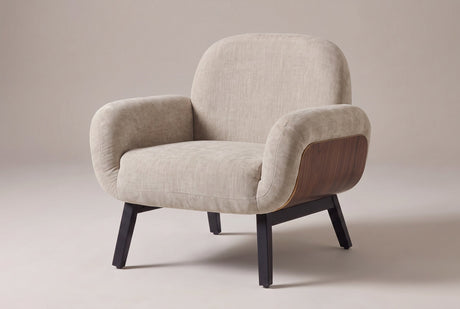 Grado shell-arm accent chair in oat chenille-look fabric, three-quarter view on a warm grey studio backdrop