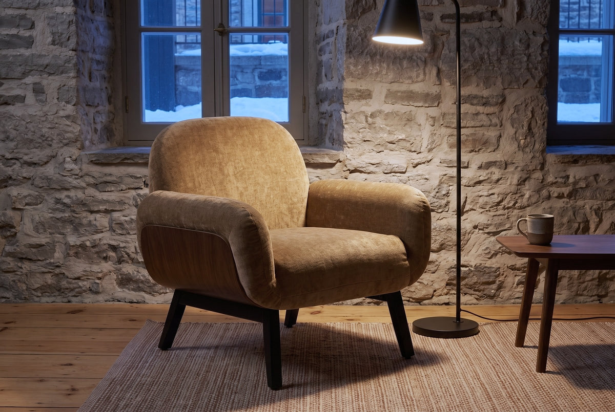Grado chair against a fieldstone wall in a Quebec City sitting room at dusk, a black floor lamp lit beside it