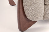 Close-up of a solid birch wedge leg in a walnut-brown stain under the boucle arm