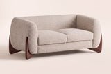Greccio boucle loveseat in almond, three-quarter view on a warm cream studio backdrop