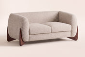Greccio boucle loveseat in almond, three-quarter view on a warm cream studio backdrop