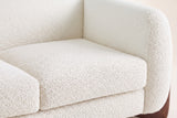 Close-up of the beige boucle seat cushion, the rounded arm and the back of the Greccio loveseat