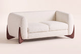 Greccio boucle loveseat in beige, three-quarter view on a warm off-white backdrop