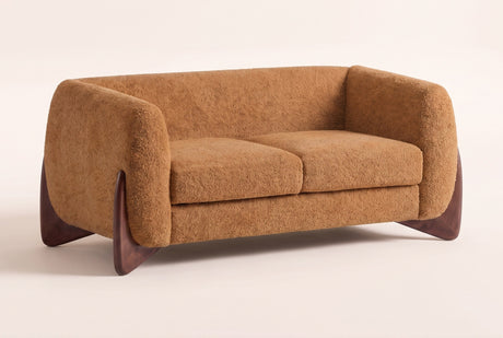 Greccio boucle loveseat in caramel, three-quarter view on a warm cream studio backdrop