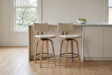 Two Gressoney counter stools in Beige / Natural at a warm white island with a marble top in a Victorian kitchen in Fredericton, elm trees through the sash window