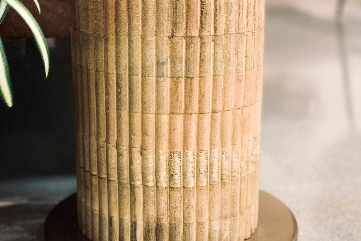 Close-up of the reeded natural wood base and round brass foot on the Hadrian lamp