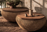 Halden teak and rattan round coffee tables on a woven rug in warm afternoon light