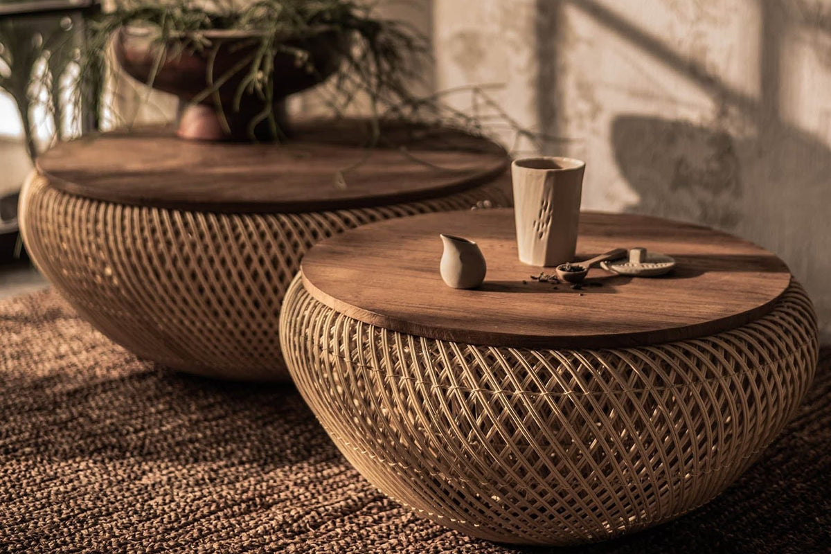 Halden teak and rattan round coffee tables on a woven rug in warm afternoon light