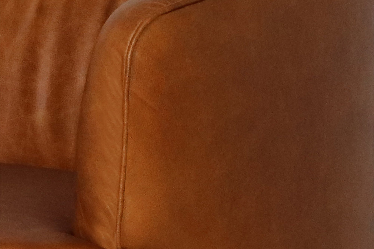 Close-up of the rounded arm and seat in Saddle buffalo leather