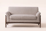 Jesi loveseat in almond boucle, straight front view: one long seat cushion, a tight back, flared arms and an arched wooden apron