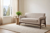 Jesi loveseat in a bright Vancouver living room with a travertine side table, a fern and a window onto cedars and mountains