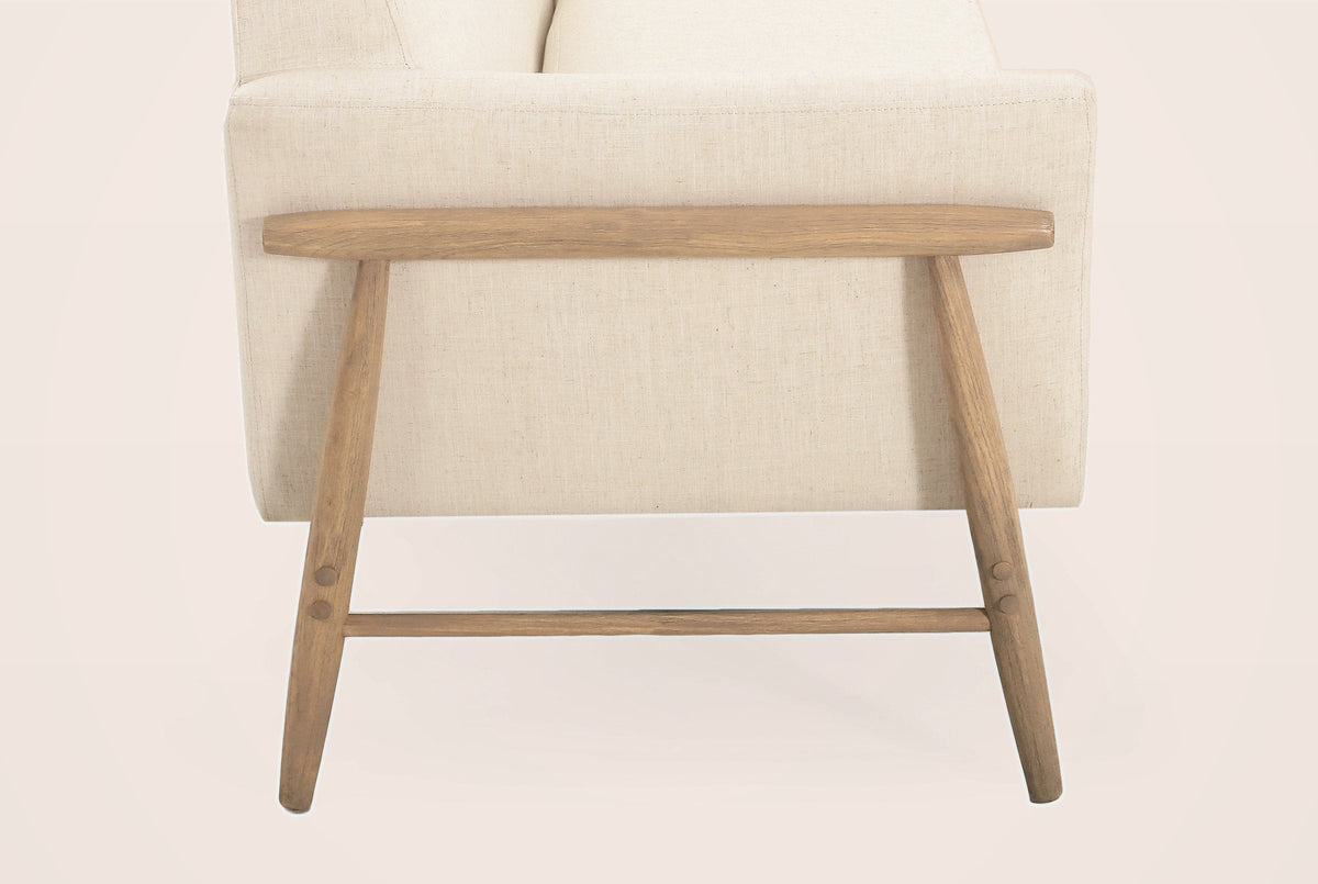 Side view of the natural-finish wooden side frame: a round arm rail, two splayed tapered legs, a low stretcher and round wooden bolt plugs