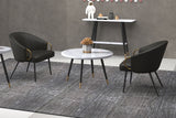 Two Kenna charcoal faux leather chairs around a round marble-top table in a grey room
