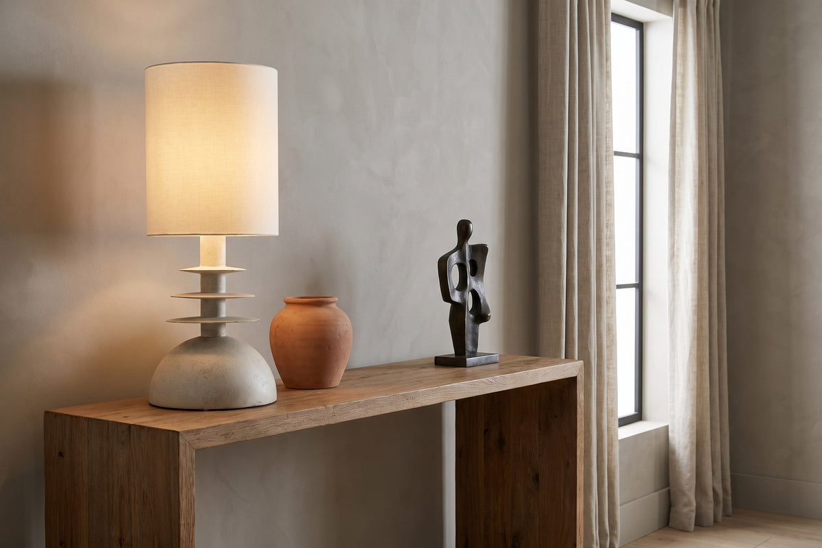Kerensa table lamp lit on a reclaimed oak console beside a terracotta jar and a bronze sculpture