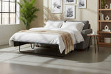 Kingsley Pepper Grey sofa bed opened into a made-up queen bed in a sunny loft