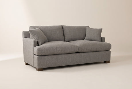 Kingsley queen sofa bed in Pepper Grey, three-quarter view on a warm off-white studio backdrop: track arms