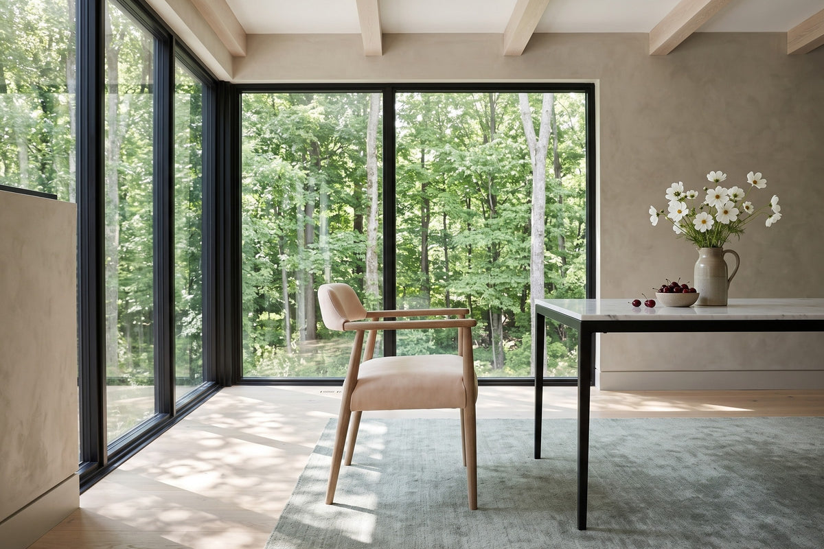 A Laigueglia armchair in Beige leather in side profile in a King Township forest house