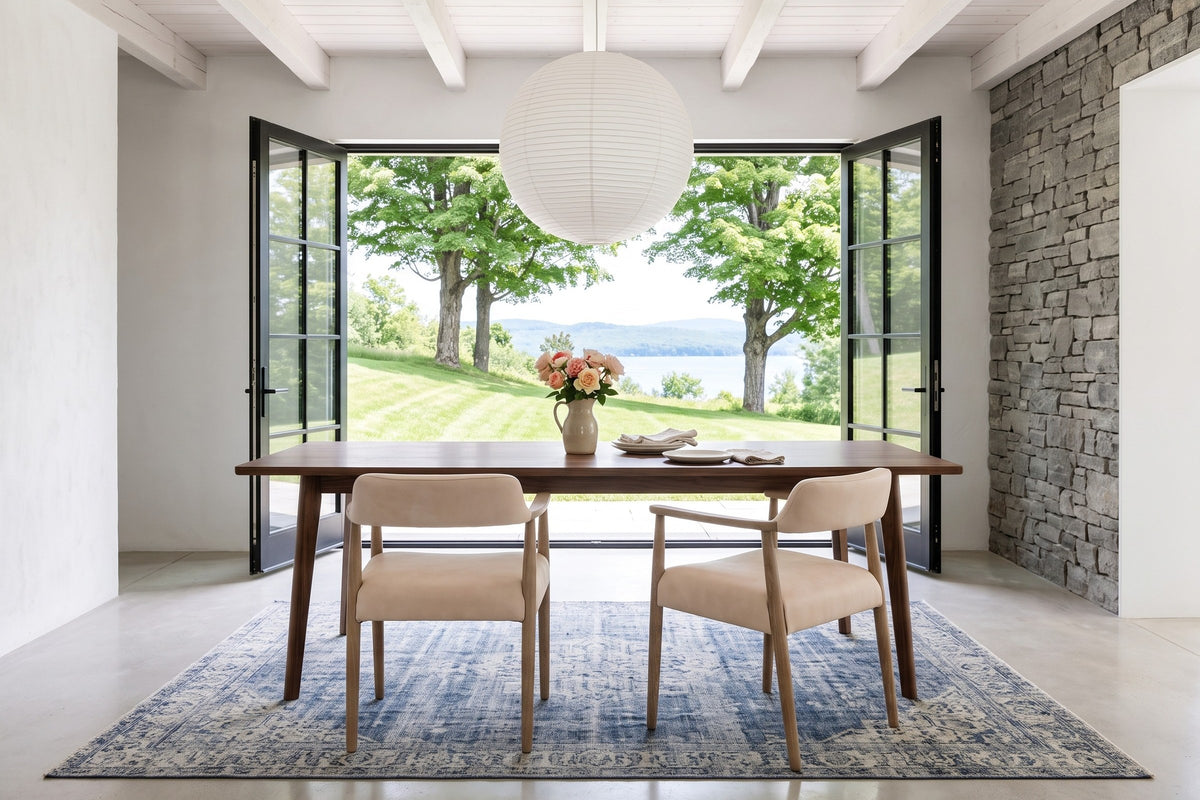 Two Laigueglia armchairs in Beige leather seen from behind at a walnut table in a Knowlton house